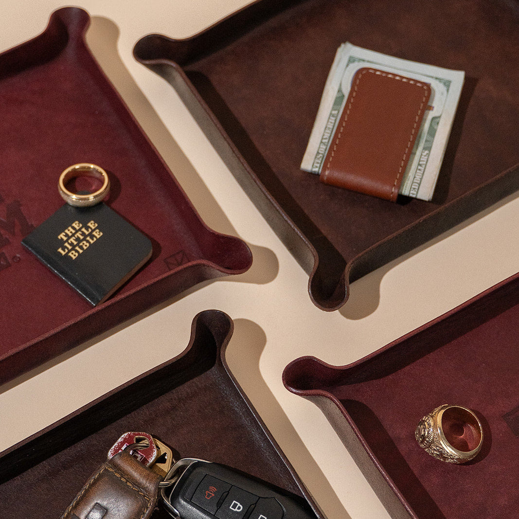 Maroon leather valet tray with Texas A&amp;M Aggies logo and gold watch and gold Aggie ring and money clip and cash 