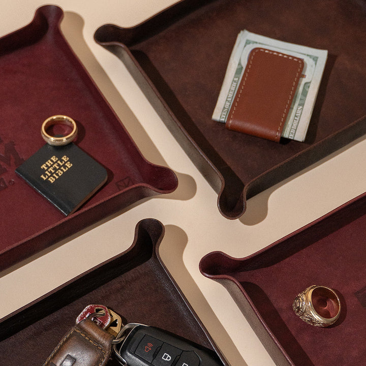 Maroon leather valet tray with Texas A&amp;M Aggies logo and gold watch and gold Aggie ring and money clip and cash 