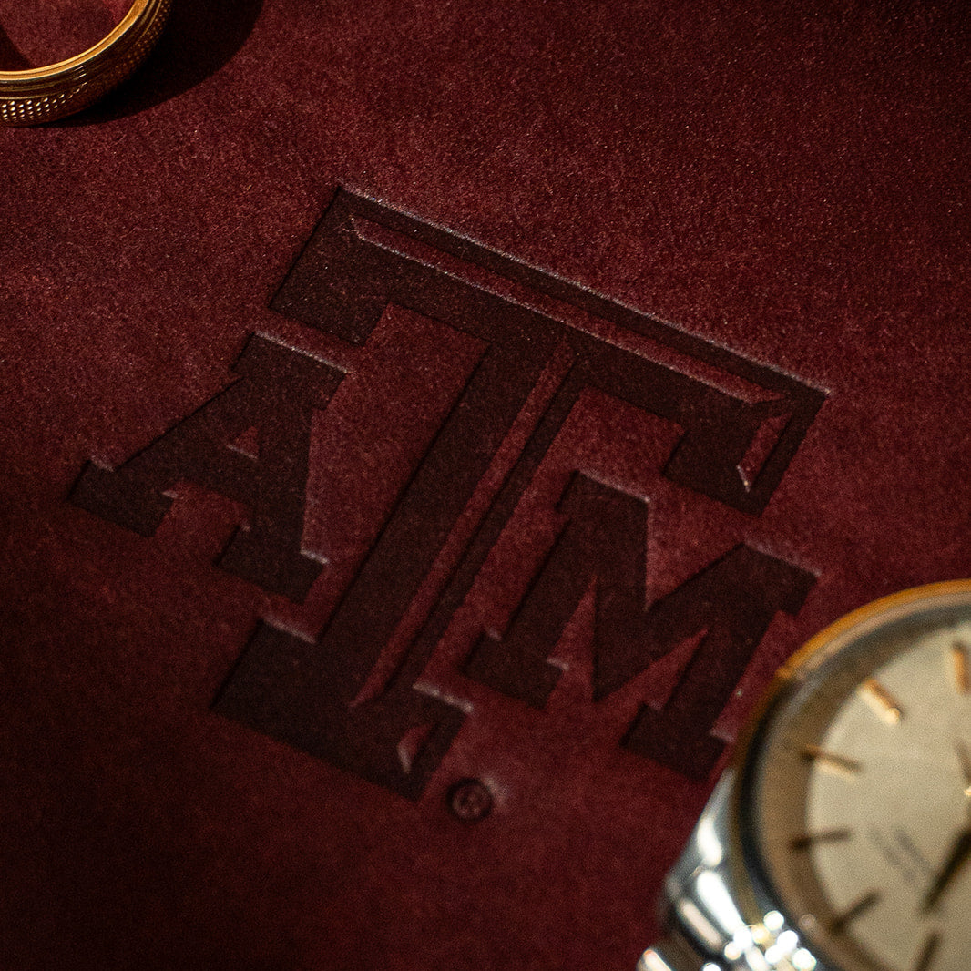 Maroon leather valet tray with Texas A&amp;M Aggies logo and gold watch and gold Aggie ring