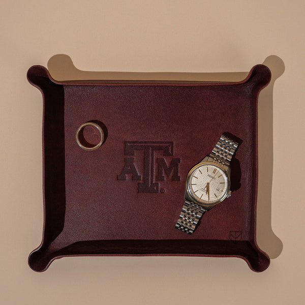 Maroon leather valet tray with Texas A&M Aggies logo and gold watch and gold Aggie ring