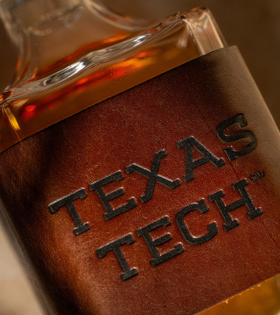 Close-up of a decanter with a premium leather wrap displaying &
