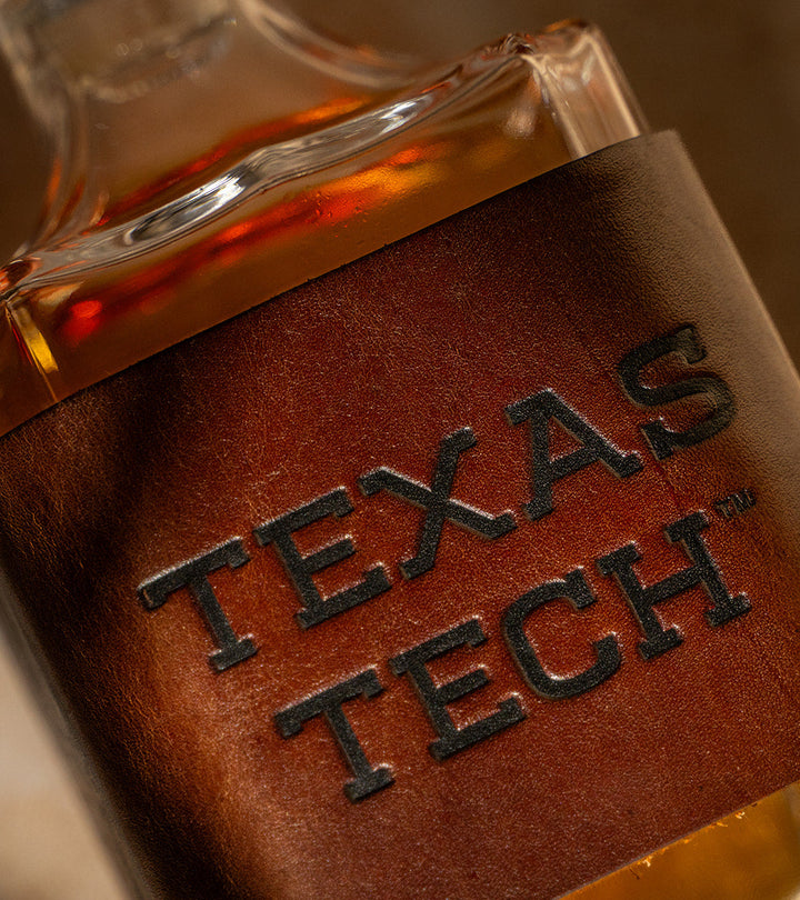 Close-up of a decanter with a premium leather wrap displaying &
