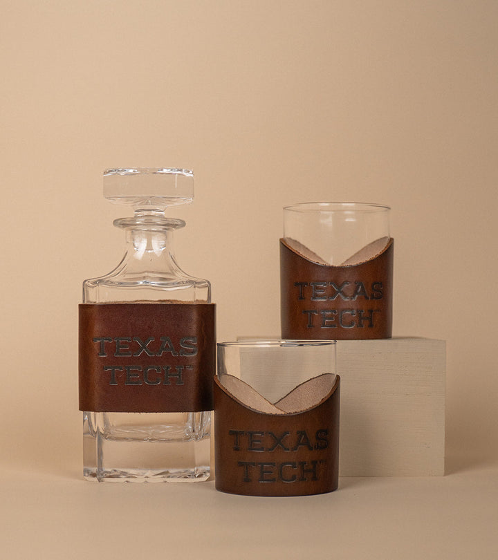 Glass decanter and rocks glasses with premium leather wraps featuring &